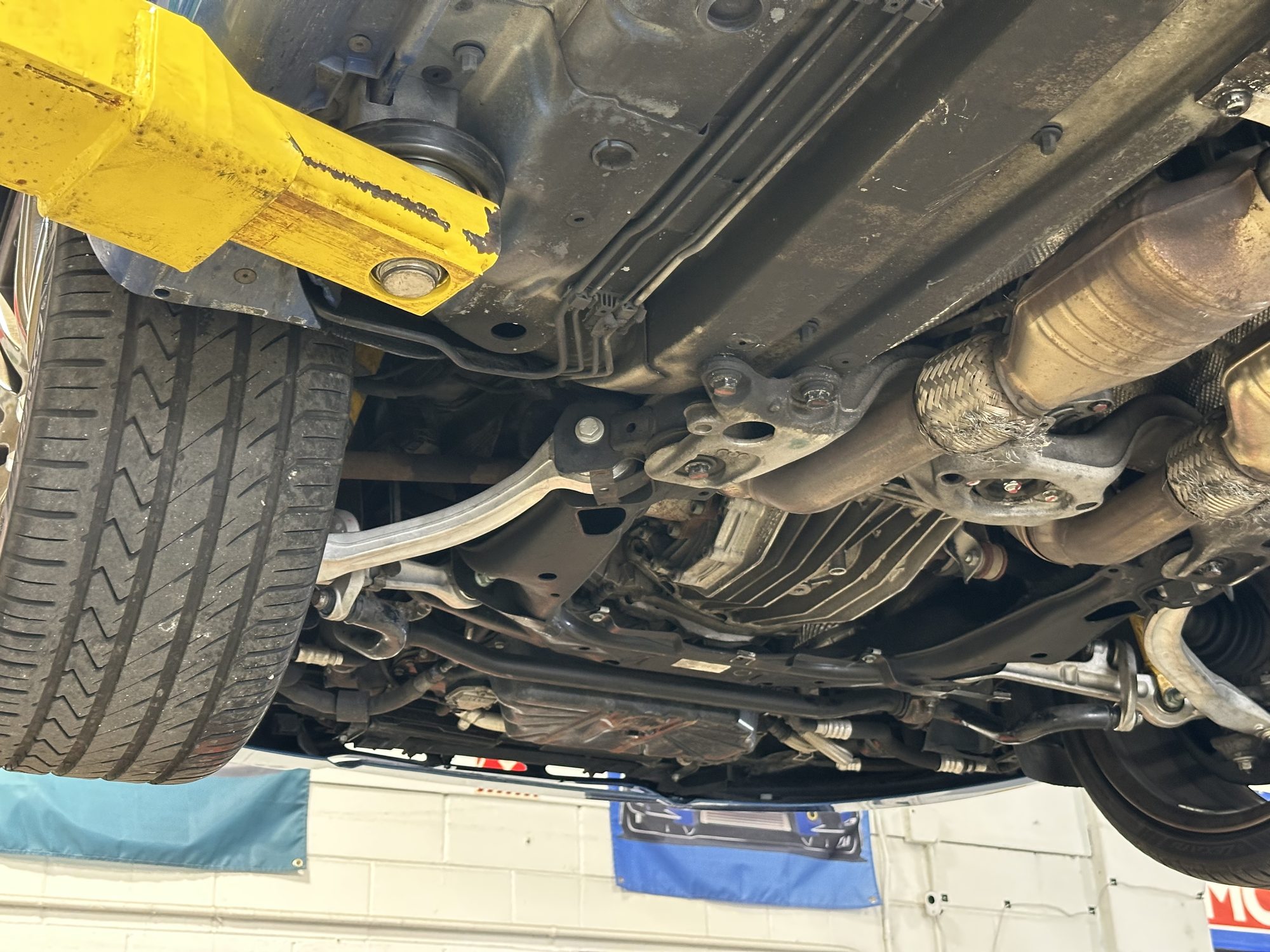Close-up of front subframe, control arm, and exhaust flex joint